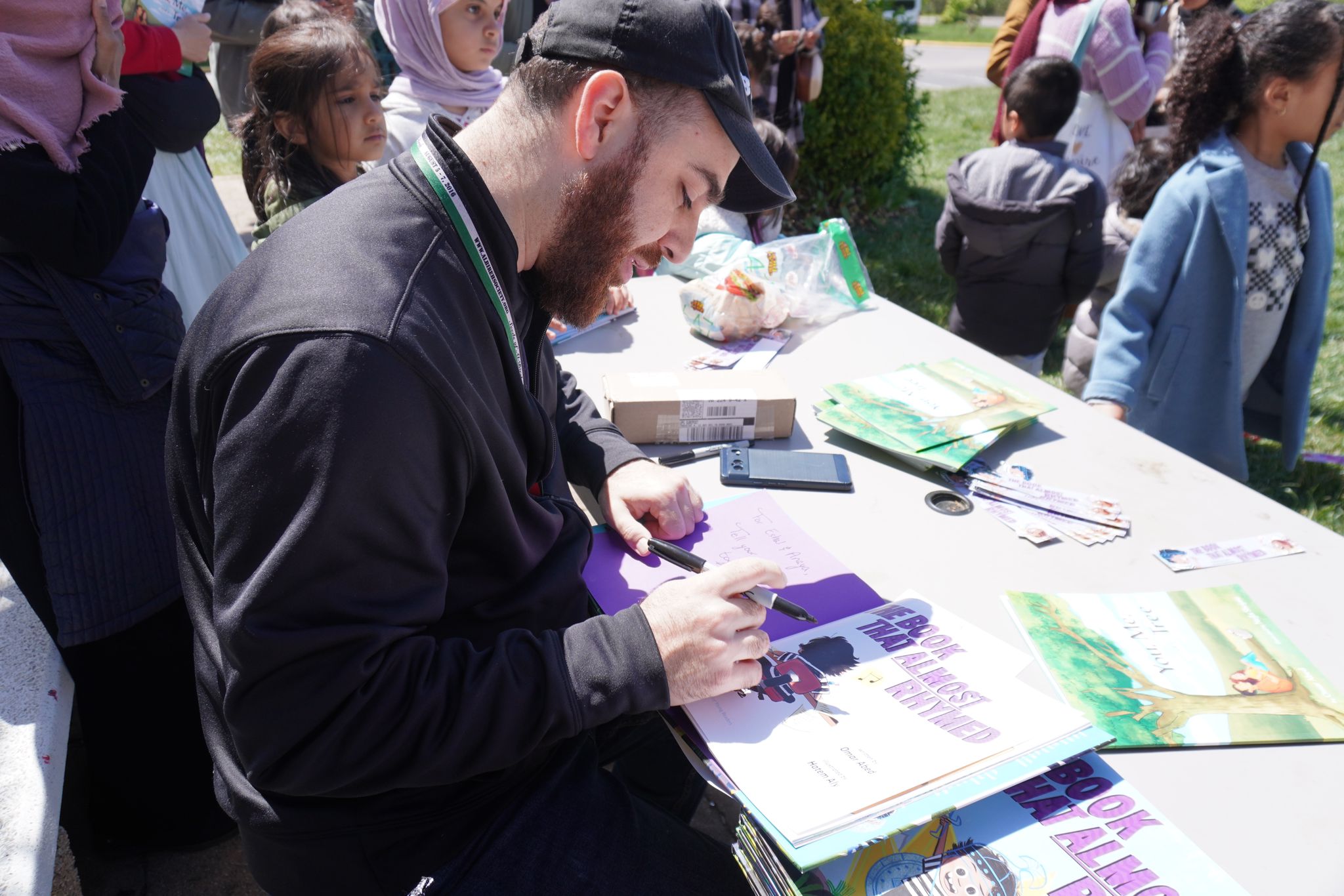 Omar signing copies of The Book That Almost Rhymed