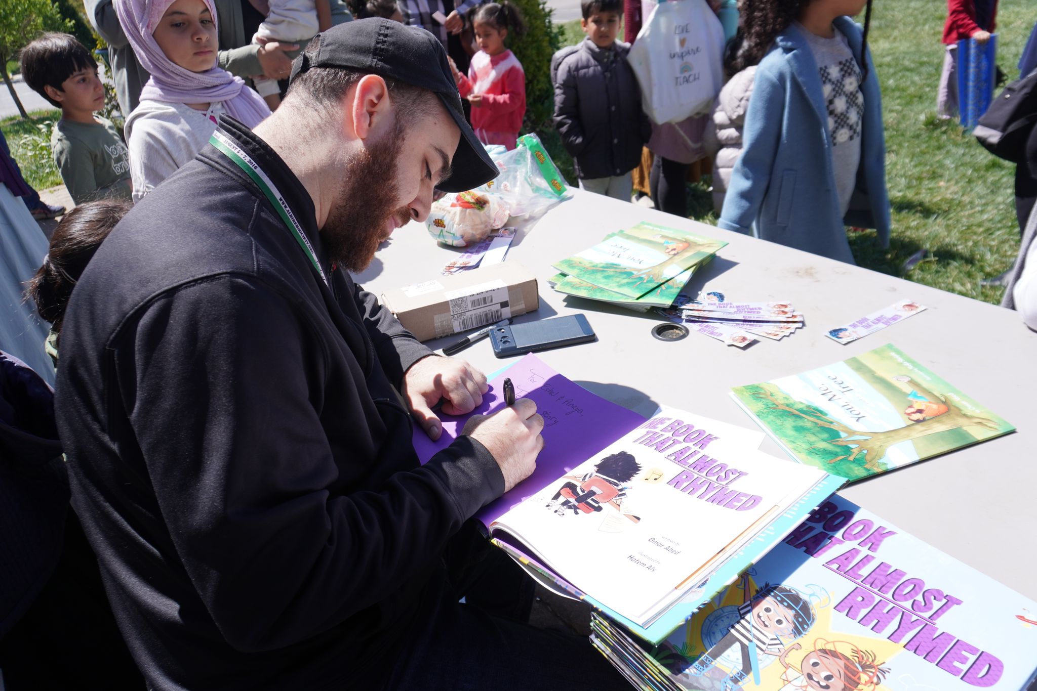 Omar signing copies of The Book That Almost Rhymed