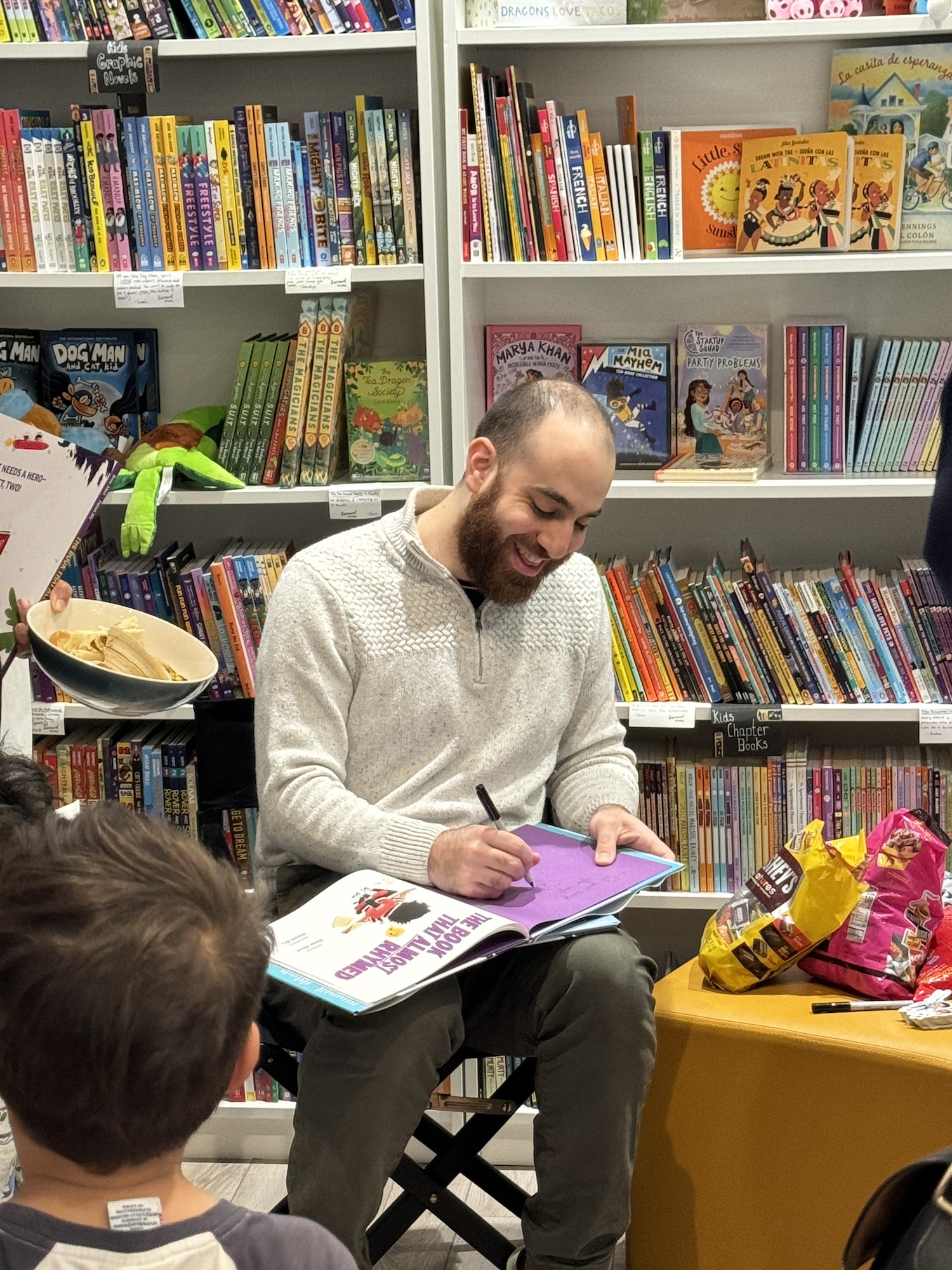 Omar signing a copy of The Book That Almost Rhymed