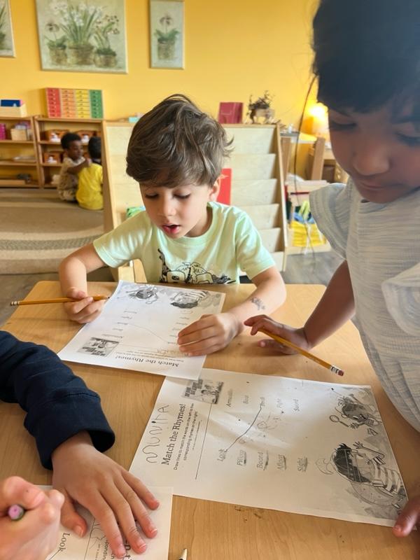 Children completing a rhyming activity sheet at Medina Montessori